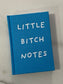 Blue book titled 'LITTLE BITCH NOTES' on a marble surface